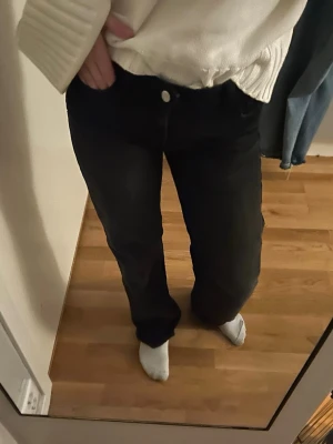 Svarta raka jeans med normal passform - Säljer ett par svarta jeans med rak passform och normal midja. Jeansen har klassisk femficksdesign och stängs med knapp och dragkedja. Perfekta till en avslappnad stil och funkar året runt.