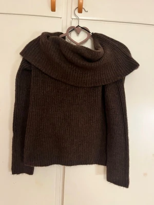 Stickad off shoulder tröja  - En jätte mysig stickad off shoulder i mörkbrunt! Så gosigt stickat material men har inte använt den nåt. Använd max 1 gång och är i helt nytt skick!
