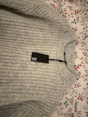 Stickad tröja - Väldigt fin grå stickad tröja från lager 157. Ny med prislapp kvar. Storlek M