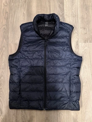 Uniqlo Ultra Light Down Vest Navy S - Mycket fint skick. (En lagning som syns knappt). Storlek S. Mått - Midja: 46,5cm, Längd: 59cm, Axelbredd: 38,5cm, Bröstvidd: 37cm. Hör av dig vid funderingar!🤝