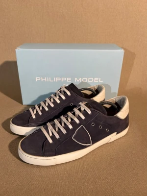 Philippe Model Prsx Men - Storlek: 42 EU = 8 UK | Färg: Marinblå | Skick: Mycket bra | Defekter: Inga | Material: Mocka | Tillbehör: Box, Dustbag och extra Skosnörren | Pris: 2399kr | Dm för frågor.