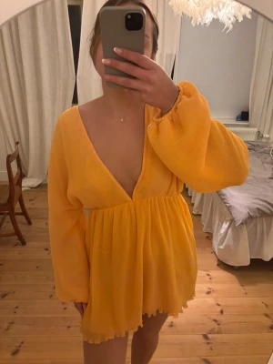 Lojsan Wallin klänning, orange m v-ringning  - Lojsan Wallin x NA-KD. St 38. Använd vid ett tillfälle. Dragkedja vid midjan. V-rigning både fram och bak. Se sista bilden för hur färgen ser ut i dagsljus!