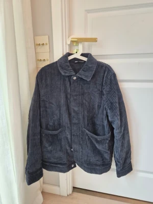 Mörkblå jeansjacka från Zara - Säljer en mörkblå jeansjacka från Zara i storlek S. Jackan har breda ribbade ränder, två stora framfickor och knäppning framtill. 