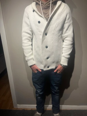 Vit stickad kofta med knappar - Säljer en vit stickad kofta med stora svarta knappar. Storlek M modellen 177cm och väger 65kg. Skriv för mer info✨✨