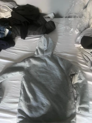 Grå hoodie med brittisk flagga - Snygg grå hoodie från Motherhead med tryck av brittiska flaggan och texten 'Beats to a British Tune' på bröstet. Klassisk känguruficka framtill och justerbar huva med dragsko. Perfekt för en avslappnad streetstyle-look.