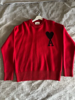 Röd stickad tröja från Ami Paris - Säljer min Ami Paris tröja i storlek M (oversized fit) då den tyvärr var för stor för mig. Tröjan är helt oanvänd och i nyskick. Kvitto finns (digitalt) kvar för att styrka äkthet, köpt via Farfetch.  Oanvänd / nyskick • 100% äkta • Kvitto finns • Original pris: ca 5000kr • Säljes för 3500kr