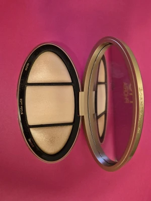 Too Faced highlighterpalett - Highlighterpalett från Too Faced med tre nyanser: Glow, Soft Focus och Dazzle. Kommer i en oval, svart och guldig dosa med spegel. Perfekt för att skapa en snygg glow och highlighta ansiktet. Puderformula som är lätt att applicera. Kan vara testad någon gång. Fin palett. 