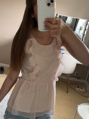 Ljusrosa volangtopp med volangdetaljer - Supersöt ljusrosa topp med volangdetaljer, det är storlek S men jag brukar ha S/xs och den sitter bra på mig 💗💗💗Kan pris diskuteras! 