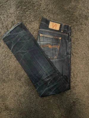  Nudie Jeans - Ett par snygga mörkblå jeans från nudie, snygg washed och clean look. Storlek 32/34. Inga defekter på de. Hör av er vid minsta fundering 🙌🏼