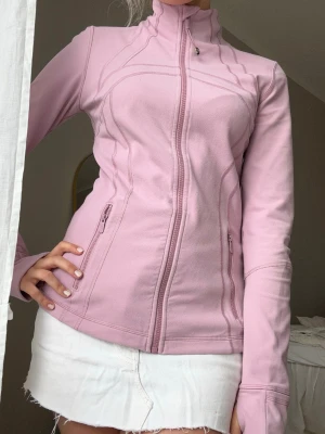 Ljusrosa Lululemon träningsjacka i fleece💖💖🌸 - Snygg ljusrosa fleecejacka med figurnära passform och hel dragkedja framtill. Jackan har hög krage och två fickor med dragkedja. Perfekt för lager-på-lager och chill dagar.