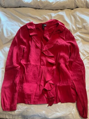 Röd blus med volang från H&M - Snygg röd blus från Vero Moda med volangdetaljer. Perfekt att styla med jeans eller kjol. Använd 3 gånger.