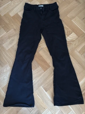 Svarta Bootcut Jeans  - Säljer ett par svarta bootcut jeans från Lindex med klassisk femficksmodell och utsvängda ben. Jeansen har hög midja och är tillverkade i ett mjukt bomullsmaterial med lite stretch. Perfekta för som gillar jeans med mjukt och luftigt utrymme samtidigt som dom är tajta och snygga ❤️🤗