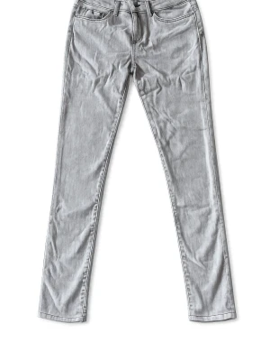 Grå skinny jeans från Tommy Hilfiger - Snygga grå skinny jeans från Tommy Hilfiger med klassisk femficksdesign och diskret logga på bakfickan. Jeansen har smal passform och är tillverkade i ett mjukt denimtyg med stretch för extra komfort.