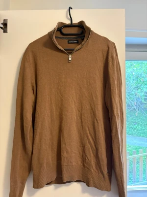 Brun stickad halfzip - Säljer en brun stickad halfzip från Jack & Jones. Använd men fortfarande i bra skick. Storlek XS
