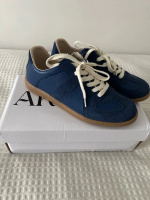 Blå sneakers från Maison Margiela  - Detta är inte Maison Margiela, utan Arveilo. De är fejkade och utger sig för att vara Maison Margiela. De är dock i perfekt kondition och har aldrig använts. Jag köpte dem för 900 kr och säljer dem eftersom storleken inte passar.