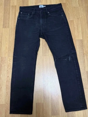 Säljer ett par custom 157 Black Jeans – Size W32 - Jeansen är i mycket bra skick. Endast använda vid något enstaka tillfälle.  Stilrena svarta jeans med en diskret ripped-detalj vid knät, vilket ger en clean men ändå edgy look. Perfekta både till vardag och streetwear.  Size: W32 L30 💸 Rabatt vid köp av flera plagg!