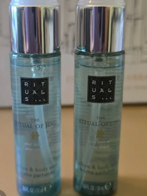 Rituals The Ritual of Jing Body Mist ( 2 st) - Fräsch och lugnande body mist från Rituals, The Ritual of Jing. Kommer i en genomskinlig ljusgrön plastflaska med silverfärgat lock. Innehåller 20 ml och har en elegant, minimalistisk design med svart etikett och guldtext.