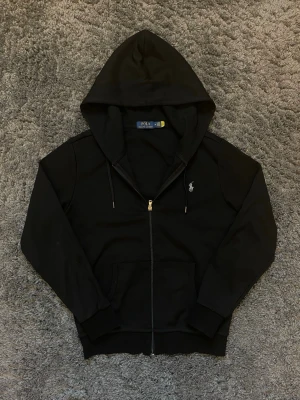 Ralph Lauren Zip Hoodie - Inga tecken på användningen✅ Det är double knit modellen så den sitter som en S. Axelbredd: 45 | Längd: 65 Går att hämta i Stockholm Skriv för fler bilder eller frågor😊