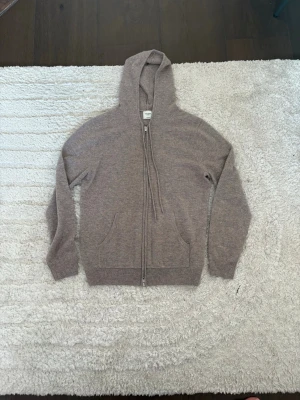 Beige cashmere hoodie från John Henric - Mysig beige hoodie i cashmere från John Henric. Tröjan har dragkedja framtill, två fickor och en huva med dragsko. Perfekt för dig som gillar stilrena och bekväma plagg i mjukt material. Använd fåtal gånger. Tveka inte vid frågor! Priset ej hugget i sten.