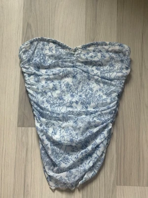 Blå blommig bandeau topp - Jättefin bandeau topp från SHEIN, med smickrande passform och bekväm att röra sig i. Endast använd fåtal gånger. 