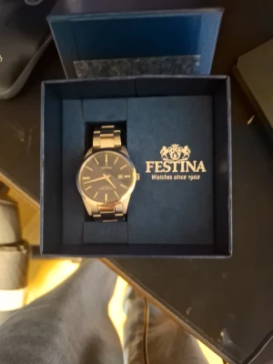 Festina silverfärgad klocka - Stilren klocka från Festina med silverfärgad länk i metall och mörkblå urtavla. Klockan har datumvisning och minimalistiska markeringar. Perfekt accessoar för dig som gillar klassisk och tidlös design.
