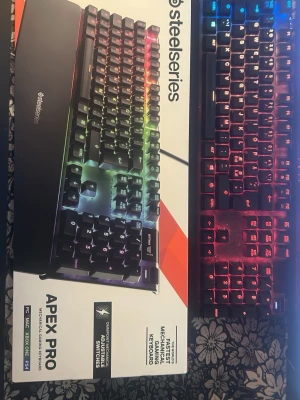 SteelSeries Apex Pro RGB tangentbord - Säljer ett SteelSeries Apex Pro mekaniskt tangentbord med RGB-belysning. Tangentbordet har justerbara mekaniska switchar och handledsstöd. Passar till PC, Mac och Xbox One. Snygg design med svart färg och regnbågsfärgad belysning.