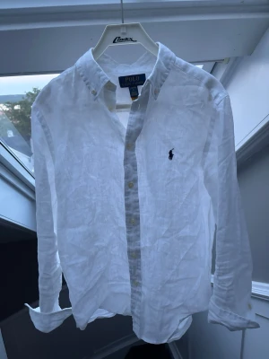 Vit Ralph Lauren linneskjorta  - Otroligt snygg linneskjorta från Ralph lauren, perfekt nu inför sommaren🤩 sparsamt använd knappt några täcken på användning. Storlek L i barnstorlek, skulle säga att den passar en xs . Pris 499 😍✅ skriv vid minsta fundering // Noel 