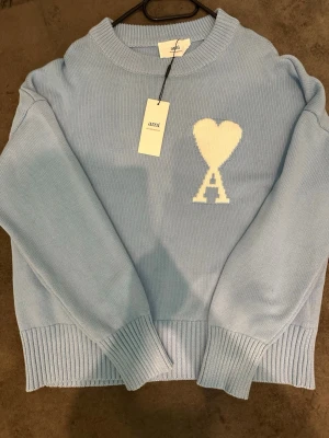 Ami Paris Heart Logo Stickad Tröja Ljusblå - Helt ny Ami Paris stickad tröja i ljusblå färg med originaltags kvar. Aldrig använd och i perfekt skick.