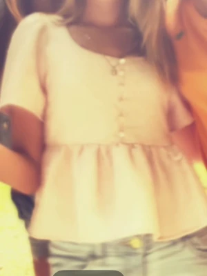 Rosa blus med pärlknappar - Supersöt ljusrosa blus med korta puffärmar och dekorativa pärlknappar framtill. Blusen har en volang nedtill och är tillverkad i ett strukturerat tyg som ger en lyxig känsla. Perfekt för dig som vill ha en feminin och trendig topp.Den passar mig som är 160/165cm