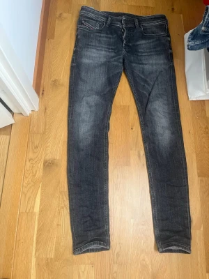 Diesel jeans - Säljer ett par mörkgrå feta  jeans från Diesel, i riktigt bra skick, tillverkade i Italien. Materialet är en blandning av bomull och polyester för extra komfort och stretch.