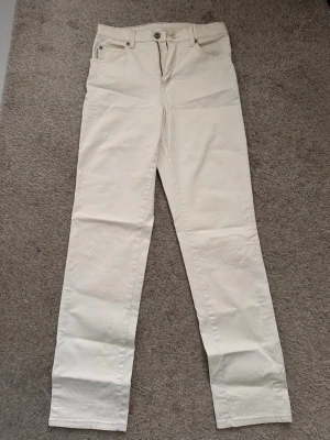 Beiga raka jeans från Flash - Snygga beiga jeans från Flash i rak modell. Byxorna har klassisk femficksdesign och är tillverkade i bomull med lite stretch för extra komfort. Perfekta att styla med en enkel t-shirt eller stickad tröja.