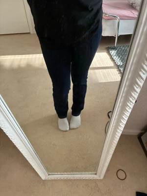 Mörkblå raka jeans - Säljer ett par mörkblå jeans med raka ben och klassisk femficksmodell. Jeansen har kontrastsömmar och normal midja. Perfekta till en avslappnad stil och passar till det mesta. Materialet känns mjukt och stretchigt för extra komfort.