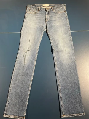 Ljusblå skinny jeans med slitning - Snygga ljusblå slim jeans med klassisk femficksdesign och slitning på vänster lår. Jeansen har en något tvättad look och raka ben. Perfekta för en avslappnad och trendig stil.