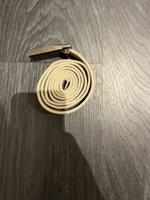 Beige bälte - Säljer detta beiga bältet då det aldrig har kommit till användning. Det är i nytt skick då det aldrig har använts.