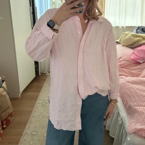 Oxford skjorta randig - Säljer en ljusrosa skjorta i oxford med vita ränder. Köpte för tre veckor sedan och har bara använt den 1 gång! Inget tecken alls på slitage, den är i nyskick🩷