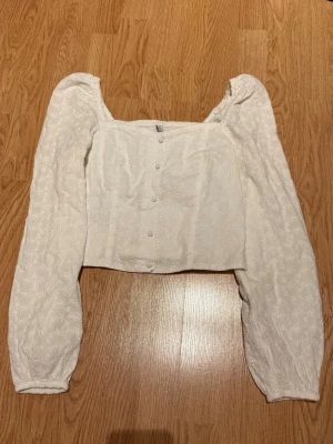 Vit blus med puffärmar och knappar - Söt vit blus med puffiga långärmar och knappar framtill. Den har en liten fläck, men det är inget som syns!💕