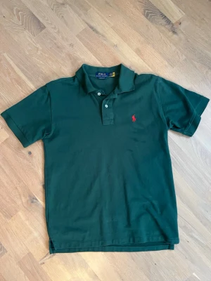 Mörkgrön pikétröja från Polo Ralph Lauren - Mörkgrön pikétröja från Polo Ralph Lauren i bra skick, storlek S. Hör av vid funderingar!