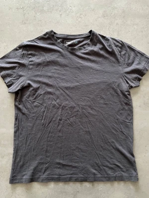 Mörkgrå basic t-shirt i bomull - L - En enkel och stilren mörkgrå t-shirt från Dressmann. Tillverkad i mjuk bomull med normal passform och rund halsringning. Perfekt till jeans eller shorts för en clean look.