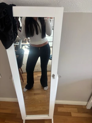 Svarta bootcut jeans med låg midja - Säljer ett par svarta bootcut jeans med låg midja och två knappar i linningen. Extremt sköna och är från Gina Young.