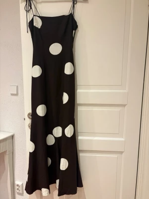 Klänning från Adoore  - Brun långklänning från Adoore med stora vita prickar och tunna axelband. Klänningen är helt ny med alla lappar kvar🤎