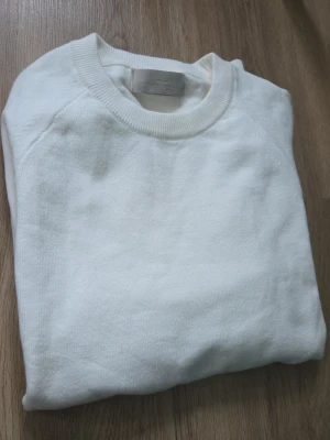 Vit stickad tröja stone island, aldrig använd  - Klassisk vit stickad tröja med rund halsringning och långa ärmar. Tröjan har ribbade muddar vid ärmslut och nederkant. Enkel och stilren design som passar till det mesta. Materialet ser ut att vara mjukt och bekvämt, perfekt för lager på lager.