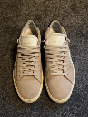 Beige sneakers från Oliver Cabell - Säljer dessa Cabells då dem är för stora för mig. Stilrena beige sneakers från Oliver Cabell med vit sula, vita snören och svart detalj på hälen. Skorna är tillverkade i mocka och läder vilket är sjukt fett till sommaren! Sidan av skon har en vit cirkel som ger en unik look vilket är sjukt snyggt!! 
