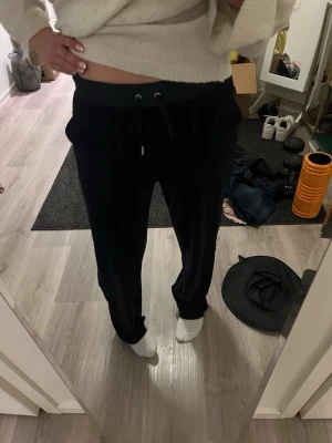 Svarta juicy byxor - Säljer ett par svarta juicybyxor med bred resår i midjan och dragsko för justerbar passform. Byxorna har raka ben och sidofickor, perfekta för chill dagar hemma eller när du vill vara bekväm. Materialet känns mjukt och skönt mot huden. Prefekt till sommaren💝