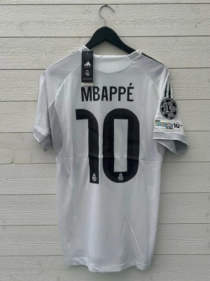 Kylian Mbappé Real Madrid Fotbollströja - Säljer en Real Madrid fotbollströja med Mbappé 10 på ryggen som är helt ny med prislapp!