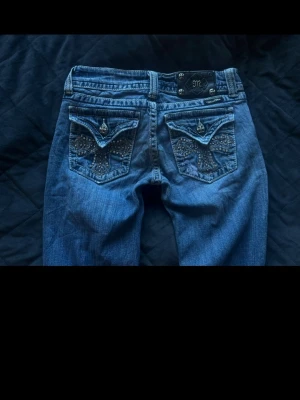  Miss Me jeans - Nu säljer jag mina superfina favoritjeans då de tyvärr inte längre kommer till användning 💕 Jeansen är i väldigt fint skick trots sin ålder väl omhändertagna och fortfarande fräscha! De har dessutom riktigt snygga och unika detaljer som många av mina vänner har gett komplimanger för.💕  Det här har länge varit mina absoluta favoritjeans🫰, men nu känner jag att det är dags för dem att få ett nytt hem. Jag hoppas att någon annan kommer att uppskatta och ta hand om dem lika mycket som jag har gjort.