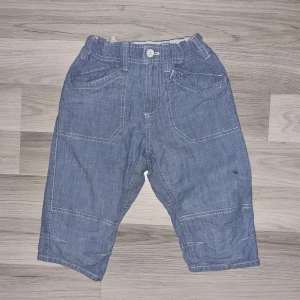 Blåa bomullsshorts med justerbar midja - Snygga blåa shorts i bomull med vita kontrastsömmar och flera fickor fram och bak. Shortsen har justerbar resår i midjan och stängs med knapp och dragkedja. Perfekta för en chill och avslappnad stil.