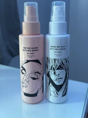 Lyko Setting Spray Duo 100 ml - Två face mist från Lyko: 'On The Glow Setting Spray' i ljusrosa flaska för daggig finish och 'Make Me Stay Setting Spray' i vit flaska med svart tecknad design för matt finish. Båda flaskorna är i plast och rymmer 100 ml vardera. Perfekt för att fixera sminket och fräscha upp huden. Båda är icke använda och nya. Du får båda när du köper.