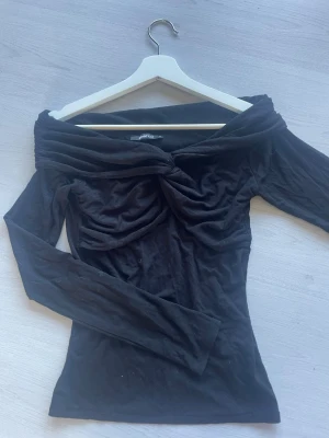 Svart off shoulder topp twistad - Off shoulder topp i stretchigt matrial, väldigt fint till bar eller fest topp. S/M