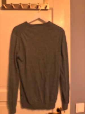 Grå stickad kasmirblandad tröja från montinique - En enkel och stilren grå stickad tröja med rund hals och långa ärmar. Tröjan har ribbade muddar vid ärmslut och nederkant, vilket ger en klassisk look. Perfekt att matcha med jeans eller kjol för en avslappnad stil.