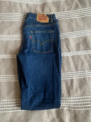 Levi’s 512 Slim Taper jeans – blå - Säljer ett par snygga Levi’s 512 Slim Taper jeans i mörkblå tvätt. Modellen har en modern passform som är slim över låren och smalnar av nedåt, vilket ger en stilren look.  Jeansen är i fint begagnat skick – inga hål eller större slitningar, endast normalt användningsslitage (se bilder). Perfekta till både vardag och lite mer uppklätt.  Detaljer: 	•	Modell: 512 Slim Taper 	•	Färg: Mörkblå denim 	•	Passform: Slim/tapered (smalare nedtill) 	•	Klassisk 5-ficksmodell